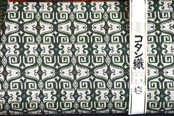 Kotan-Ori Kimono Bag close up showing the Ainu inspired green and ivory woven pattern and paper label