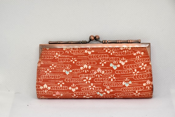Kaga Yuzen Silk Coin Purse front flat view displaying the warm orange-red base and delicate floral patterns