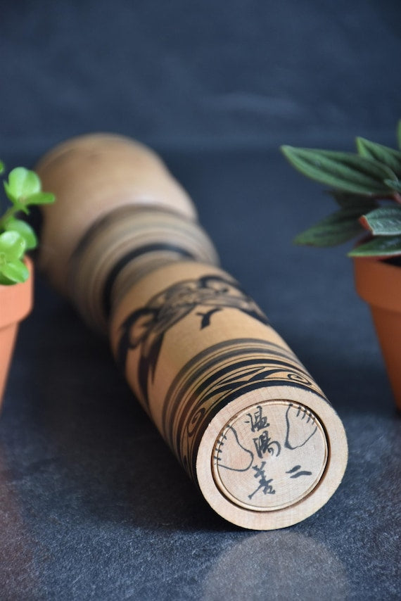 Zenji Sato kokeshi doll base showing the signature and hand-drawn feet