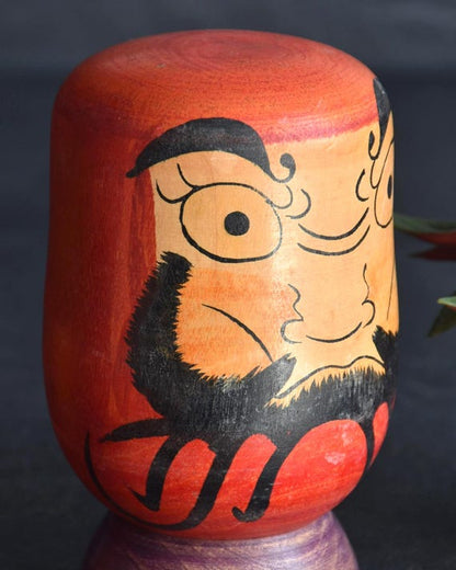 Japanese Daruma Figurine kokeshi doll close-up of the front face and beard design
