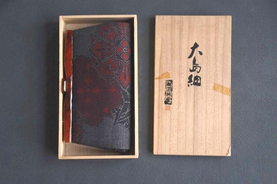 Oshima Tsumugi Kimono Bag neatly placed inside its original open paulownia wood box