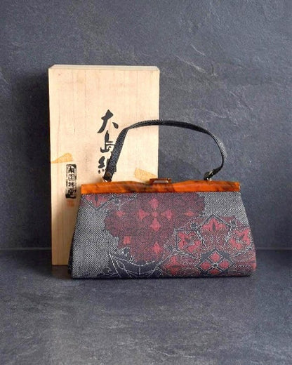 Oshima Tsumugi Kimono Bag handcrafted from authentic silk with traditional geometric patterns displayed with wooden box