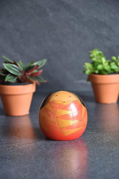 Sosaku Kokeshi by Yamagishi Masayoshi featuring bold geometric carvings and sunset orange