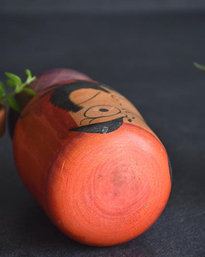 Japanese Daruma Figurine kokeshi doll angled view focusing on the top and facial details