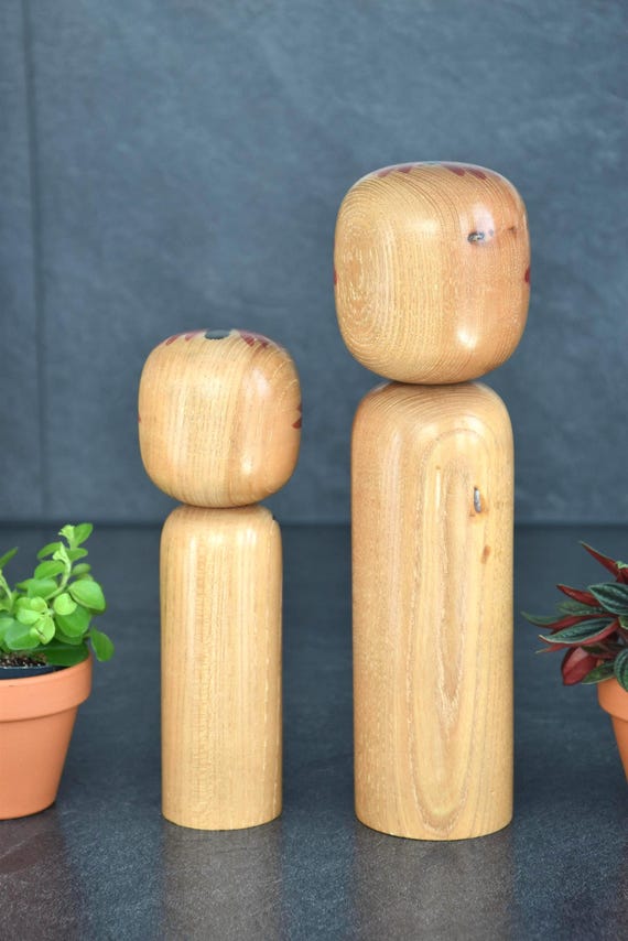 Takahashi Hashime kokeshi pair showing the smooth untreated wooden grain on the back of the dolls