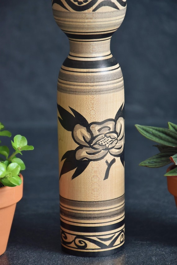 Zenji Sato kokeshi doll body detail showing the painted floral motif