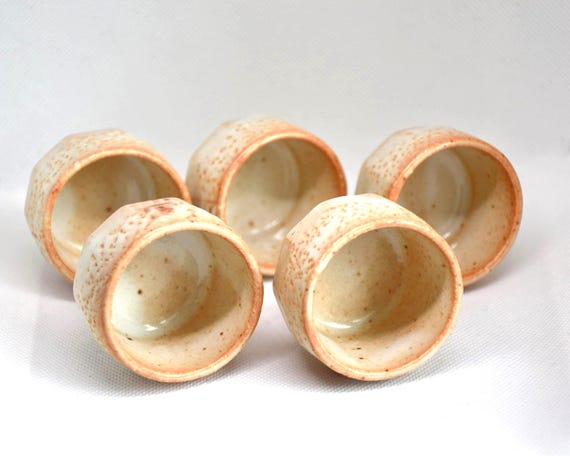 Top view of five Shino ware ceramic guinomi sake cups displaying their wide openings