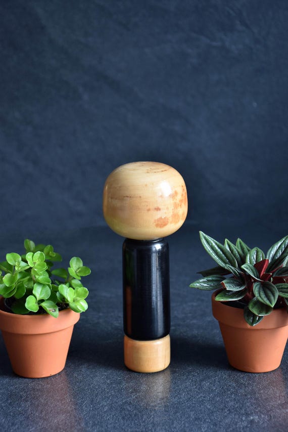 Vintage Japanese kokeshi doll with poem showing the back view of the wooden head and body.