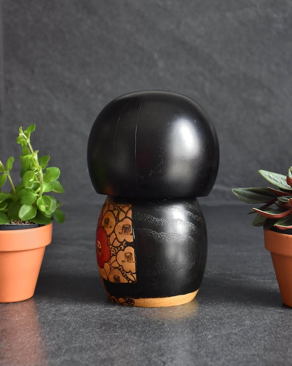 Kazuo Takamizawa creative kokeshi doll showing the black painted back and rounded head