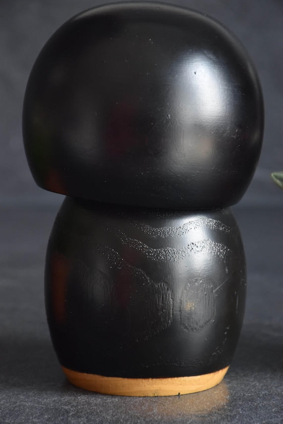Kazuo Takamizawa creative kokeshi doll close up view of the textured black wooden back