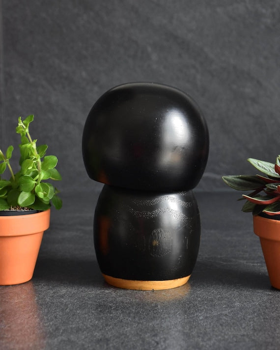 Kazuo Takamizawa creative kokeshi doll showing the rear view of the black wooden body