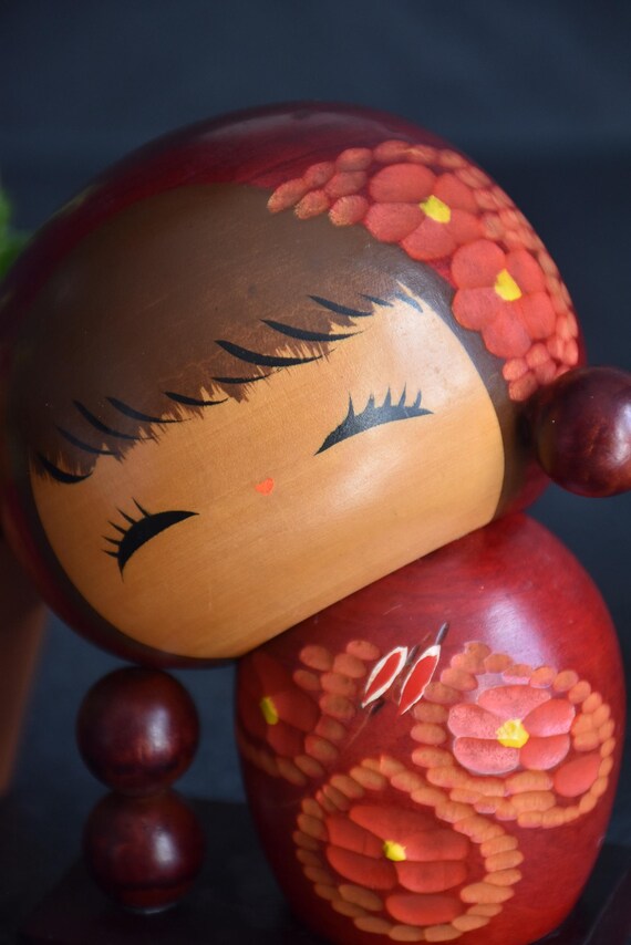 Chie Tamura Pigtail Kokeshi close up of face with painted closed eyes and hair