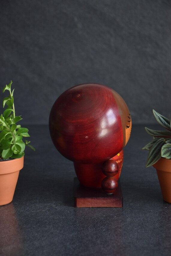 Chie Tamura Pigtail Kokeshi doll reverse side view showing wooden grain texture