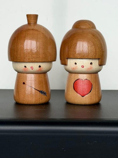 Masashi Takeda kokeshi dolls front view showing the Cupid arrow and pink heart details
