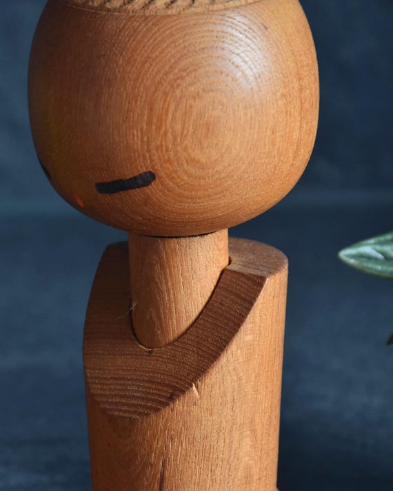 Aida Seihou kokeshi doll upper body close up showing hand painted minimalist face and closed eyes