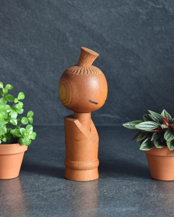 Aida Seihou kokeshi doll viewed from a slight angle emphasizing the natural grain of the wood