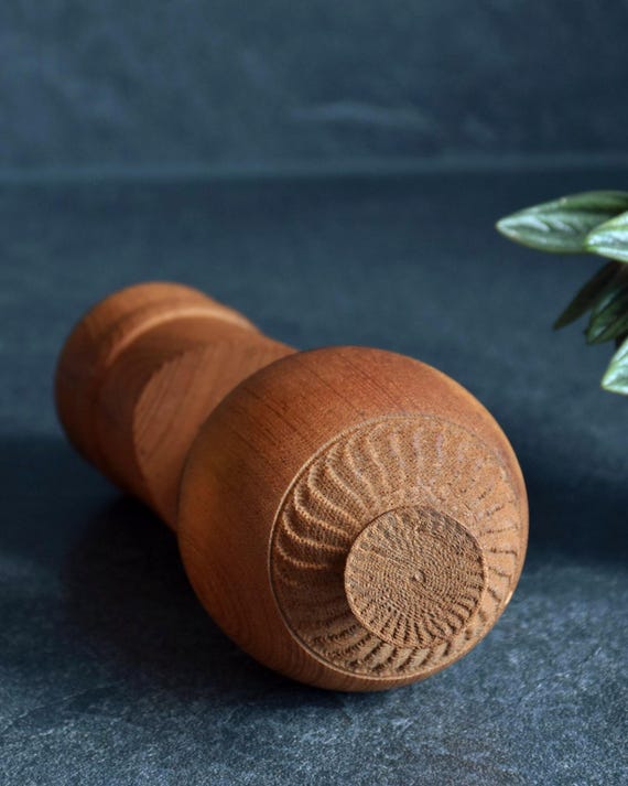 Aida Seihou kokeshi doll underside showing the chiseled wooden base texture and circular rings