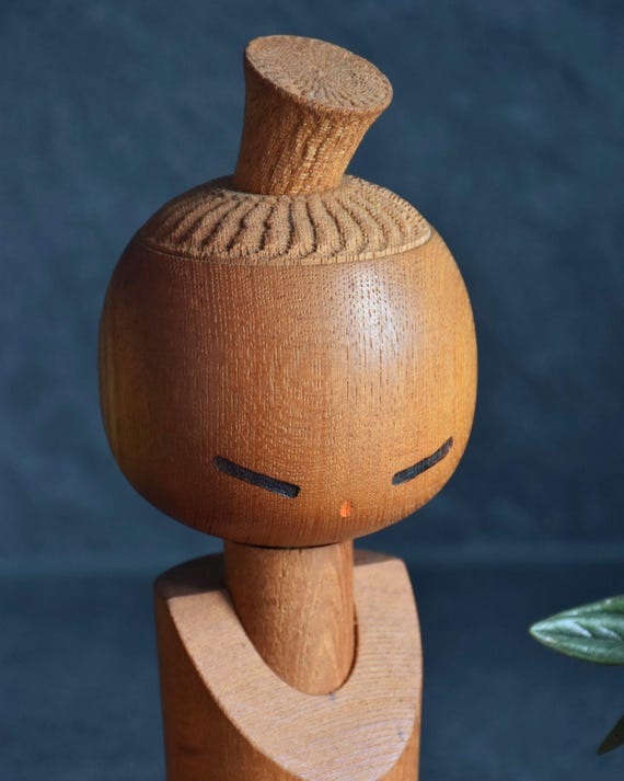 Aida Seihou kokeshi doll head detail showing the chiseled chattering texture on the crown and topknot