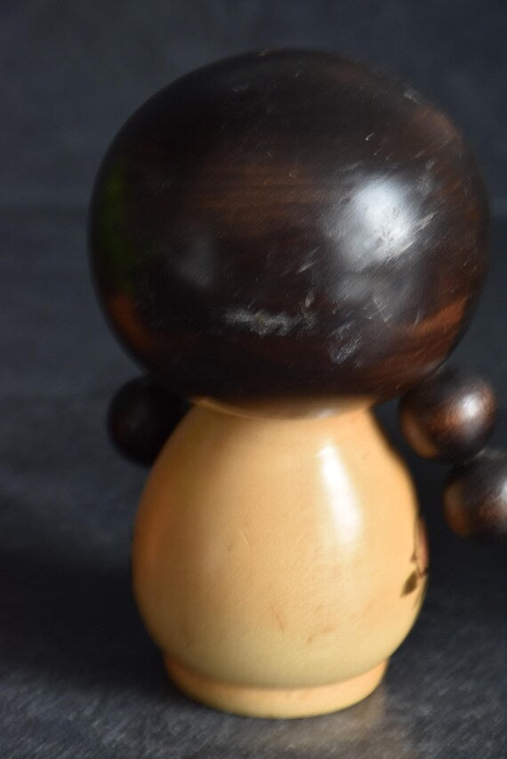 Jiro Tsuda kokeshi doll close-up of the dark wooden head showing age-related wear