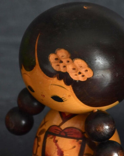 Jiro Tsuda kokeshi doll detail of the painted hair decoration and smiling face