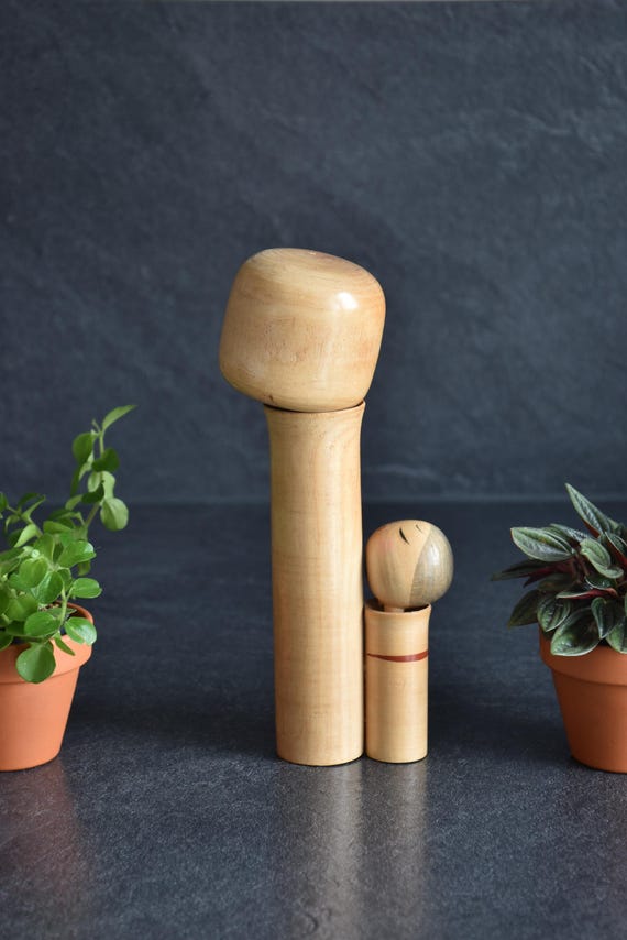 Oshin Kokeshi by Sato Suigai shown from another side angle highlighting the wood grain.