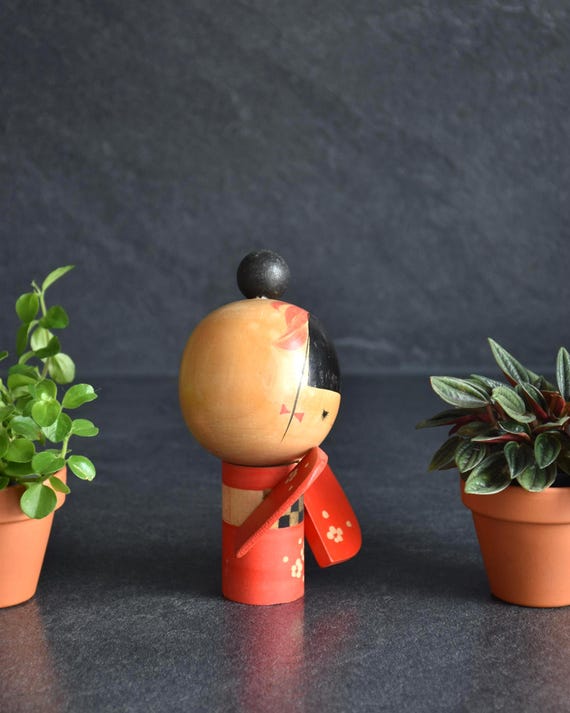 Sansaku Sekiguchi red kokeshi doll side view of the wooden craft