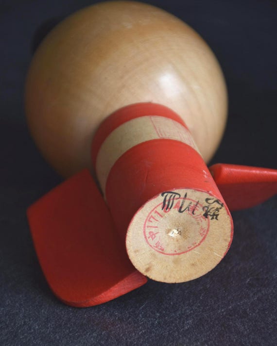 Sansaku Sekiguchi red kokeshi doll base with artist signature and stamp