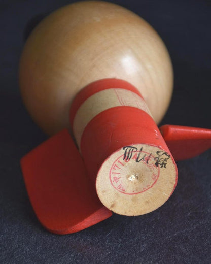 Sansaku Sekiguchi red kokeshi doll base with artist signature and stamp