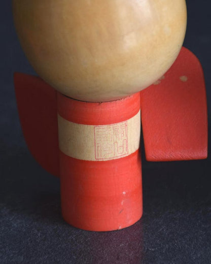 Sansaku Sekiguchi red kokeshi doll back showing the maker stamp on the body