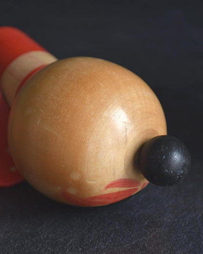 Sansaku Sekiguchi red kokeshi doll top view showing the rounded head