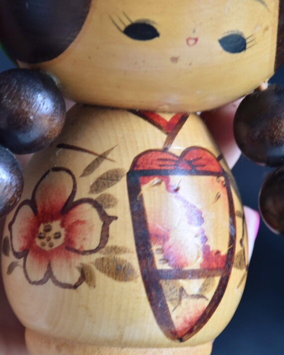 Jiro Tsuda kokeshi doll close-up of the traditional kimono painted with red flowers
