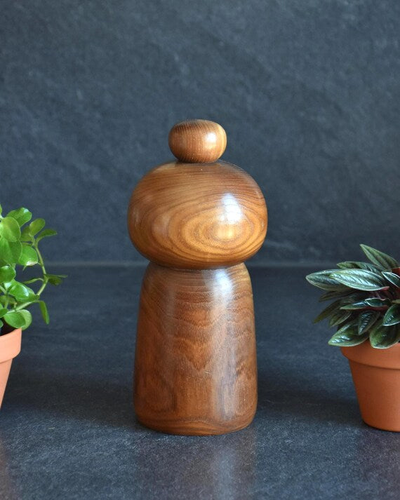 Kazuo Takamizawa kokeshi doll back view highlighting natural wood grain and rounded form