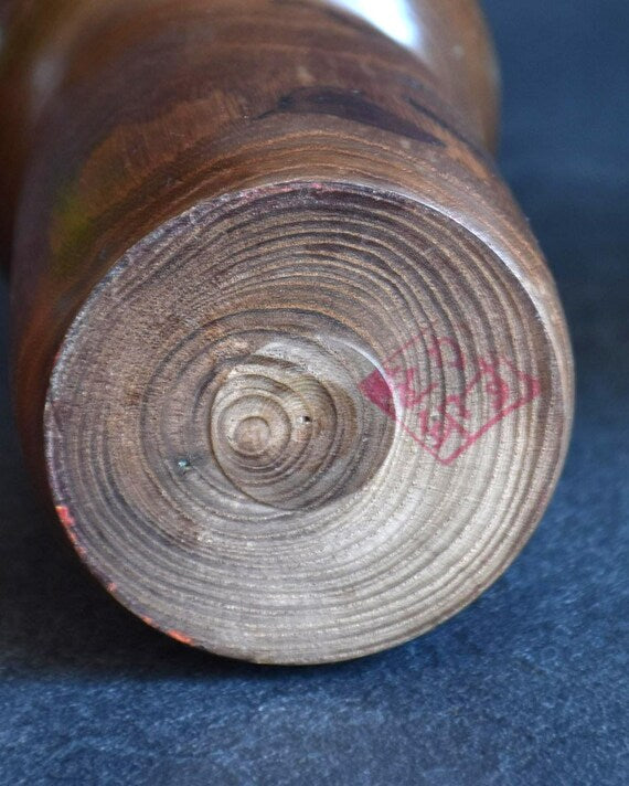 Kazuo Takamizawa kokeshi doll base showing circular wood grain and artisan red signature stamp