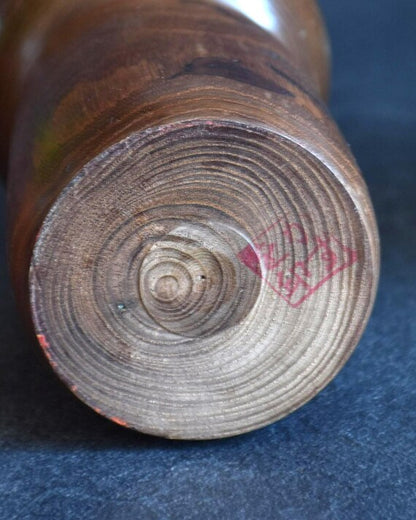 Kazuo Takamizawa kokeshi doll base showing circular wood grain and artisan red signature stamp