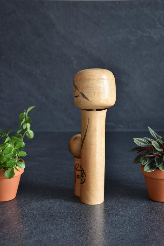 Oshin Kokeshi by Sato Suigai viewed from the side showing the rounded wooden head shape.
