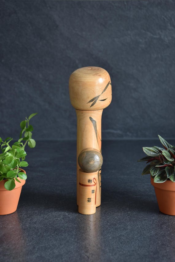 Oshin Kokeshi by Sato Suigai seen from the back showing the smooth turned wood surface.