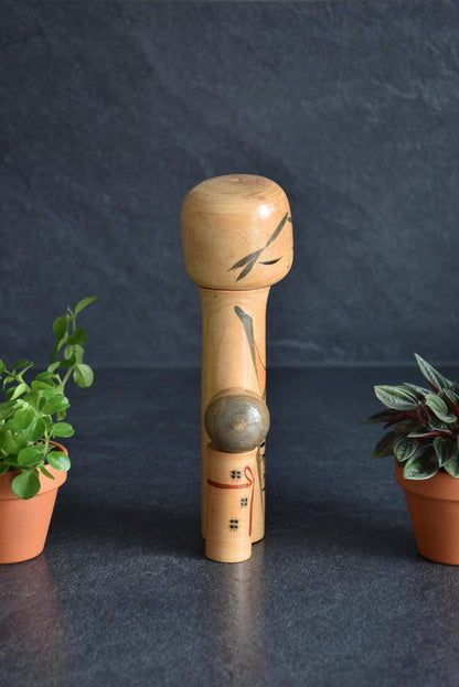 Oshin Kokeshi by Sato Suigai seen from the back showing the smooth turned wood surface.