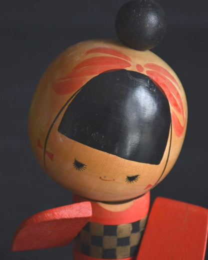 Sansaku Sekiguchi red kokeshi doll face detail with minimalist features