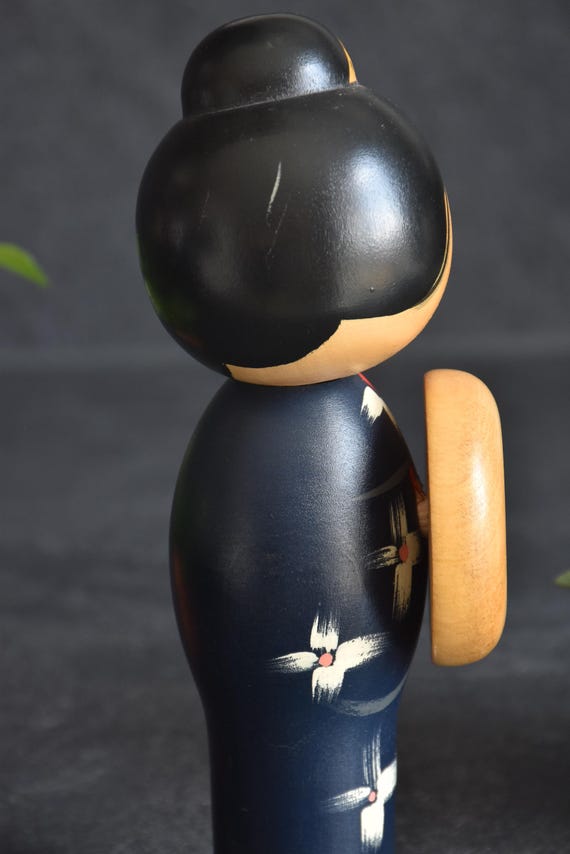 Miyashita Hajime kokeshi doll back view, showing details of the black updo and floral kimono pattern