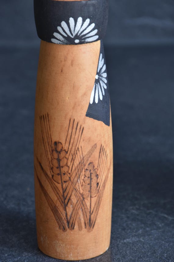 Sato Suigai kokeshi pattern detail of the black obi with white floral motifs and wheat stalks