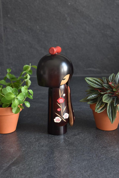 Hajime Miyashita When Flowers Bloom Kokeshi doll profile view showing plum blossom kimono motif