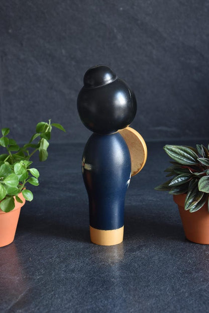 Miyashita Hajime kokeshi doll viewed from the back, highlighting the smooth black updo hairstyle