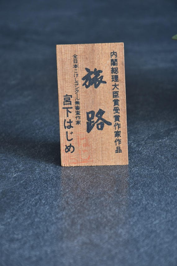 Original wooden sign included with the Miyashita Hajime traveler kokeshi doll with Japanese text