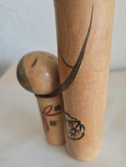Oshin Kokeshi by Sato Suigai close-up showing the smaller child figure and bamboo artwork.