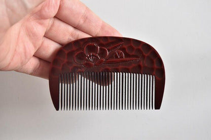 Kamakura-Bori Plum Blossom Comb held in hand showing full front view