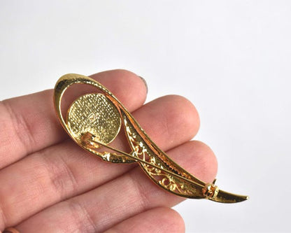Amita Damascene Floral Brooch back held in a hand showing the reverse side