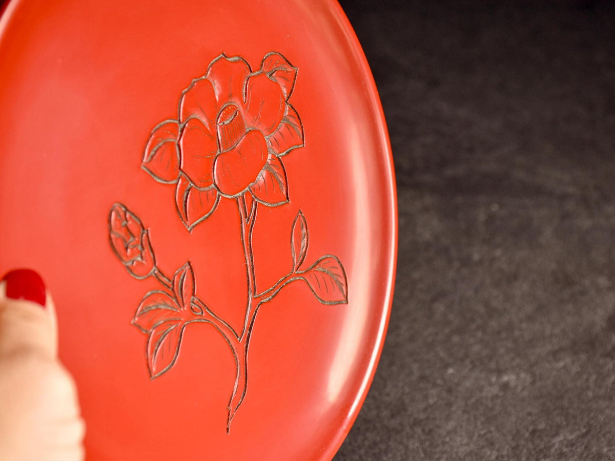 Murakami Kibori Tsuishu Camellia Red Lacquer Plate held by hand demonstrating the scale and depth