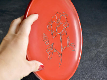 Murakami Kibori Tsuishu Camellia Red Lacquer Plate held up to show the profile and hand scale