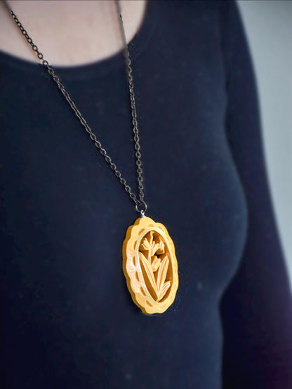 Oyama tsuge wood tulip pendant necklace worn against a black top showing how it hangs