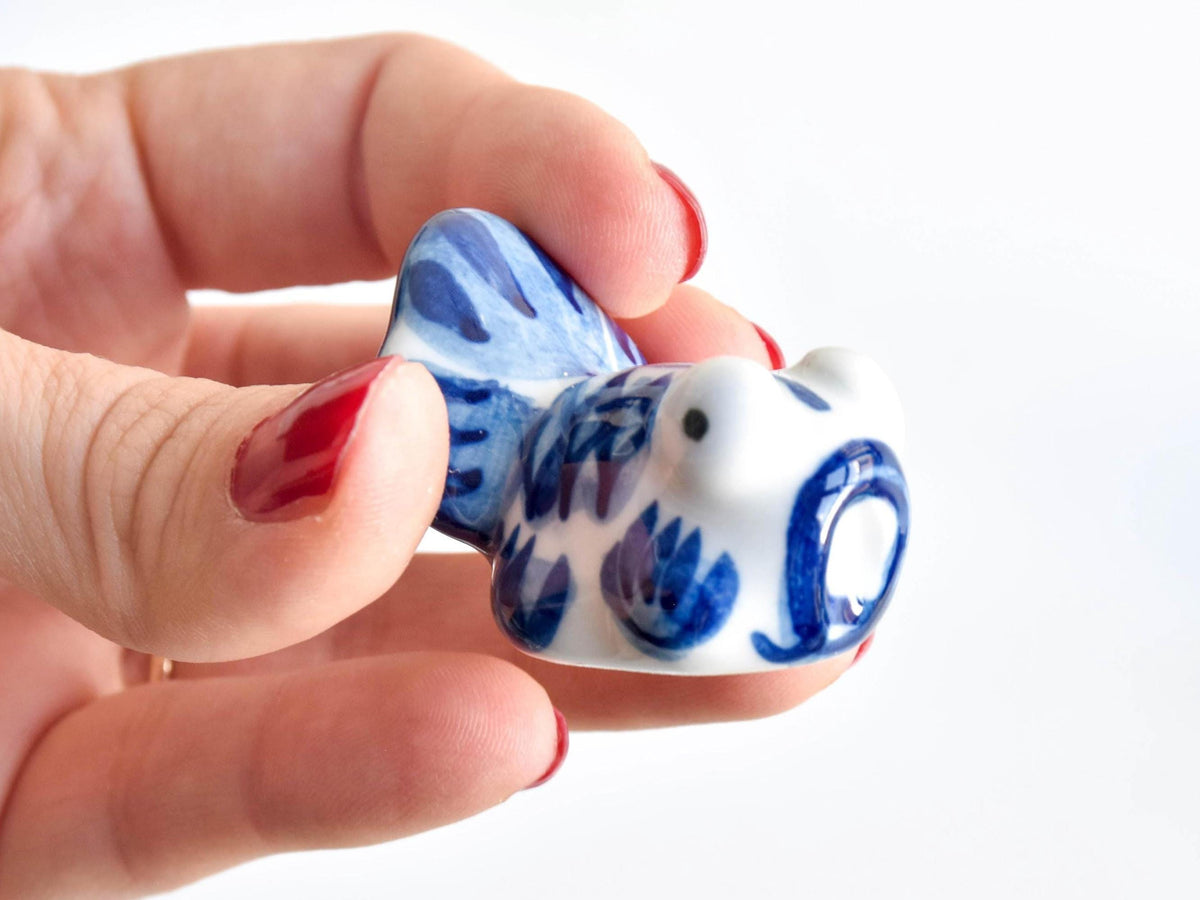 Arita-Yaki porcelain goldfish chopstick rest shown from a side angle held in a hand for scale and proportion